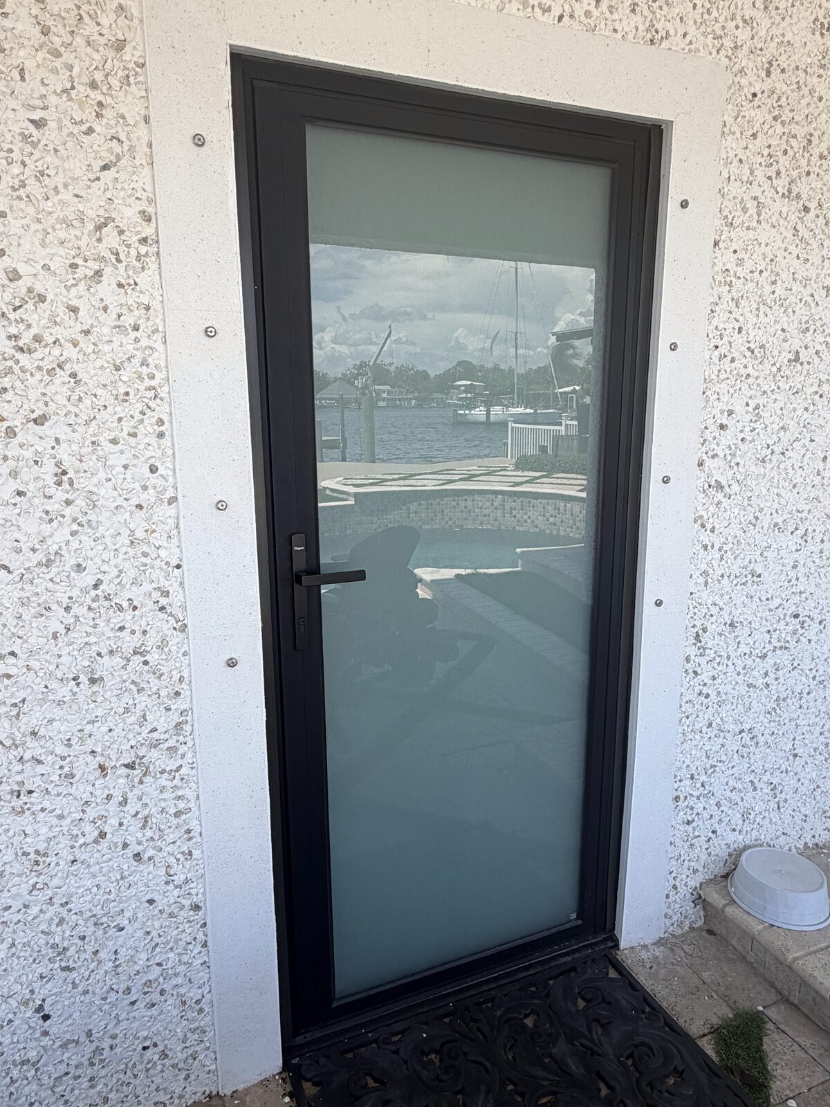 Black-framed glass entry door overlooking the water