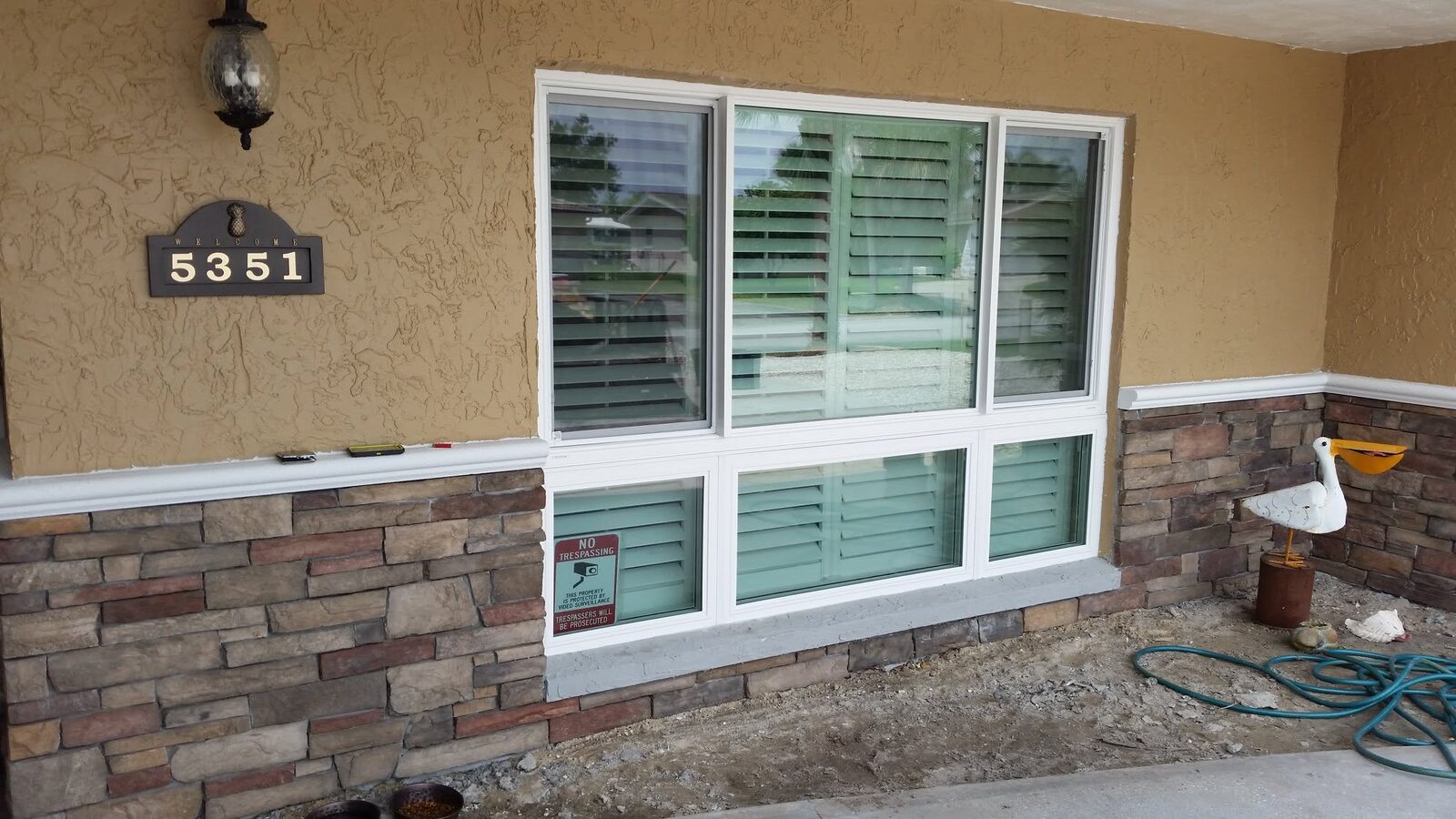New white-frame windows on a stone-accent home